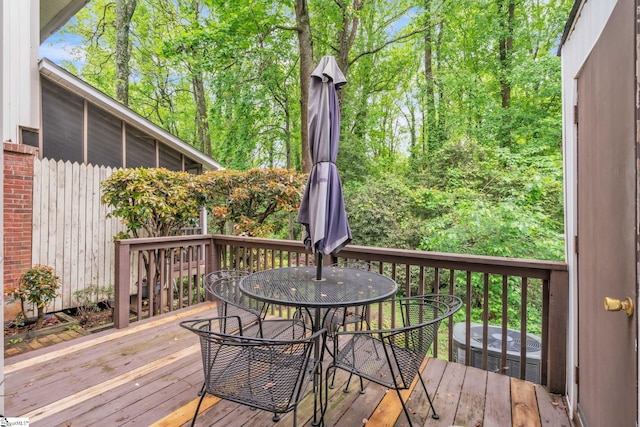 wooden deck with outdoor dining area and central AC unit