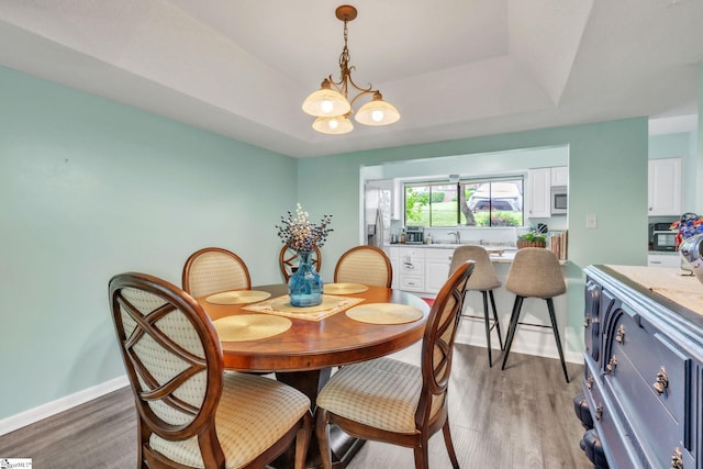 dining area featuring baseboards, a chandelier, and light wood-style floors