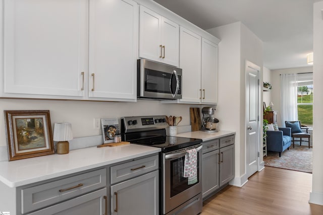 313 Glendon St, Greer, SC 29651 - kitchen featuring white cabinetry, gray cabinetry, stainless steel appliances, light countertops, and light wood finished floors