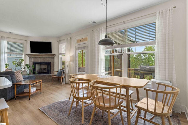 313 Glendon St, Greer, SC 29651 - dining room with visible vents, light wood-style flooring, and a brick fireplace