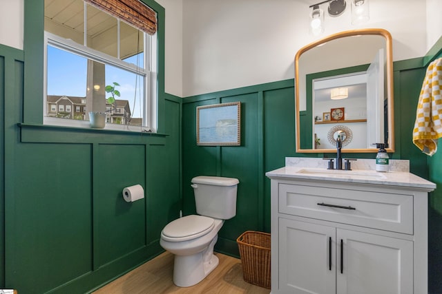 313 Glendon St, Greer, SC 29651 - bathroom with vanity, toilet, a wainscoted wall, a decorative wall, and wood finished floors