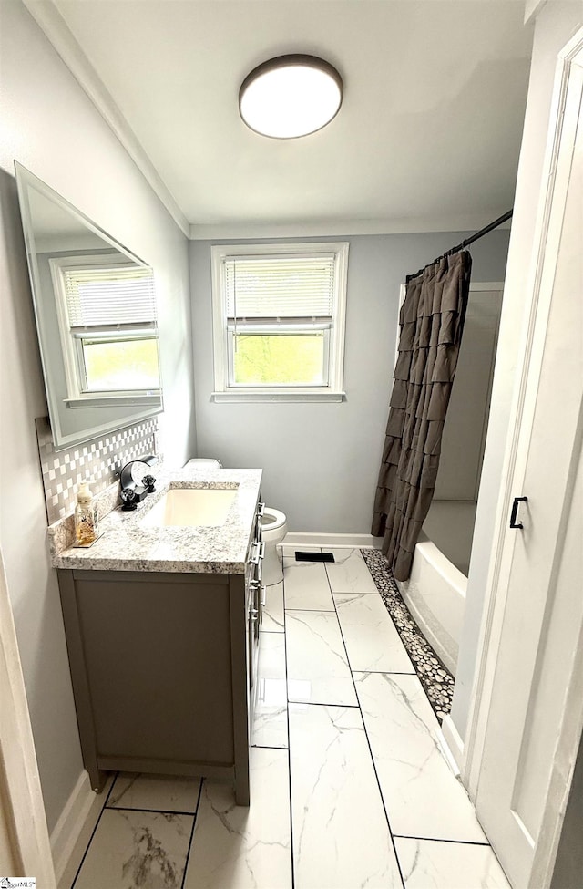 bathroom with baseboards, toilet, vanity, and marble finish floor