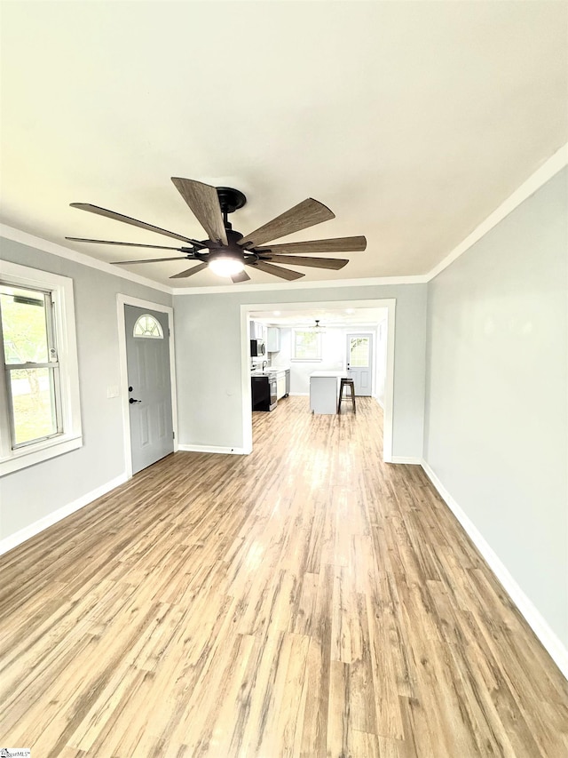 unfurnished living room featuring baseboards, wood finished floors, and ceiling fan