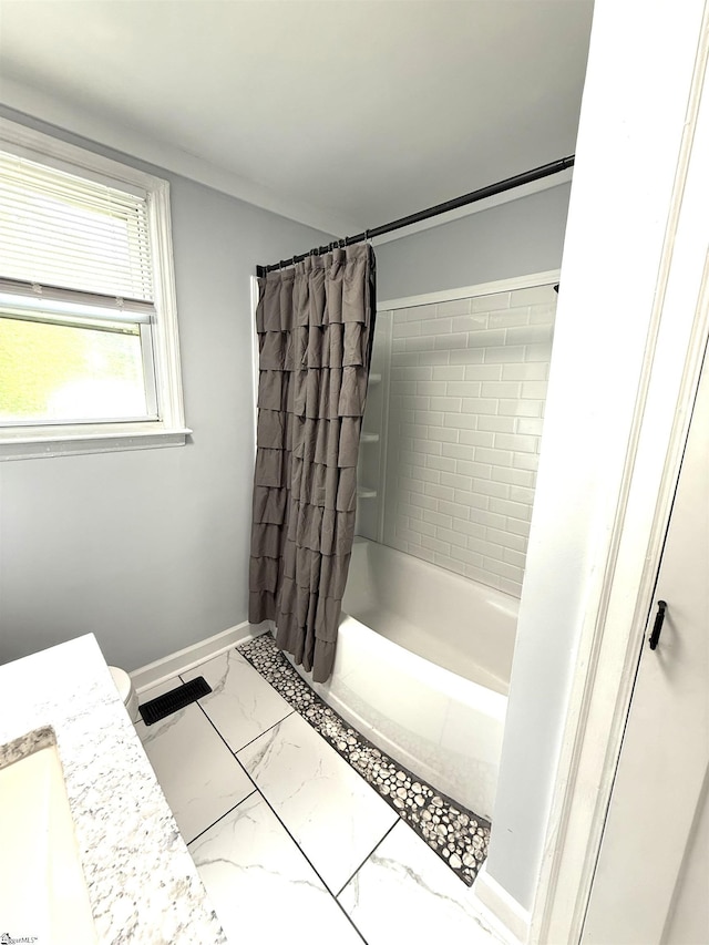 bathroom with baseboards, shower / bath combination with curtain, and marble finish floor