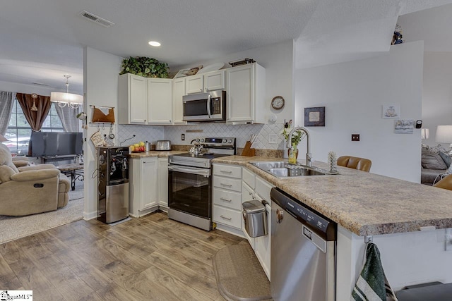 3 Heatherfield Dr, Simpsonville, SC 29680 - kitchen featuring a sink, appliances with stainless steel finishes, visible vents, light wood-style floors, and a peninsula