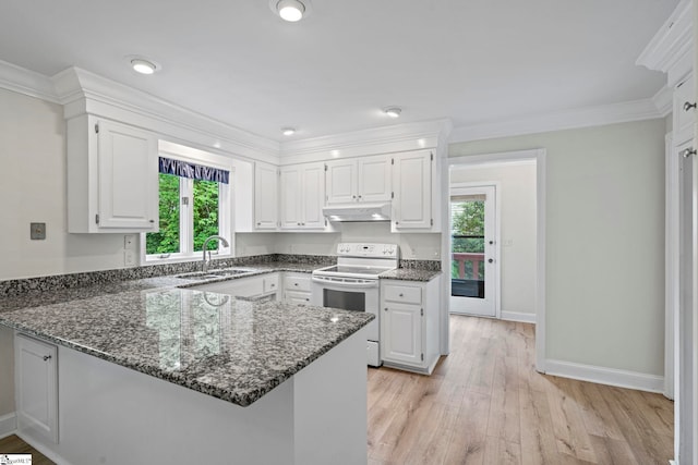 kitchen with dark stone counters, white range with electric cooktop, under cabinet range hood, a sink, and a peninsula