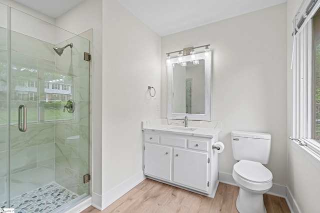 full bath with wood finished floors, toilet, a shower stall, and baseboards