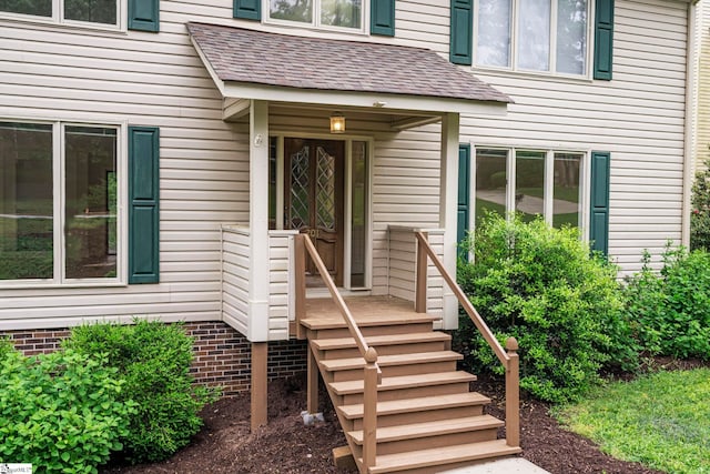 doorway to property featuring a shingled roof