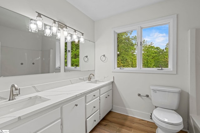 bathroom with baseboards, a wealth of natural light, and a sink