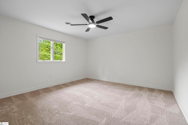 carpeted empty room with a ceiling fan and baseboards