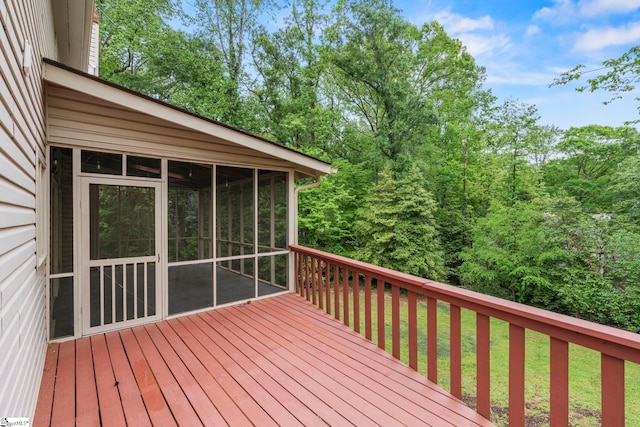 wooden terrace with a yard and a sunroom