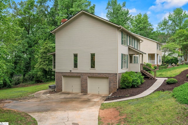 view of property exterior featuring a chimney, a lawn, brick siding, concrete driveway, and an attached garage