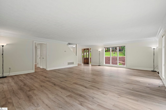 unfurnished living room with baseboards, visible vents, light wood-style flooring, and crown molding
