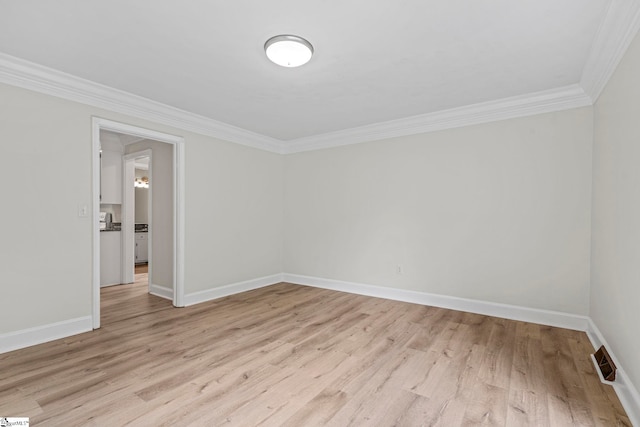 unfurnished room with light wood finished floors, visible vents, and ornamental molding