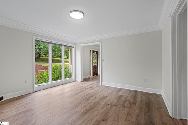unfurnished room featuring wood finished floors, crown molding, visible vents, and baseboards