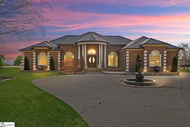 view of front of home featuring brick siding and a front yard