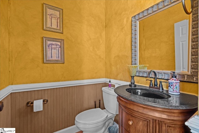 half bathroom with vanity and toilet