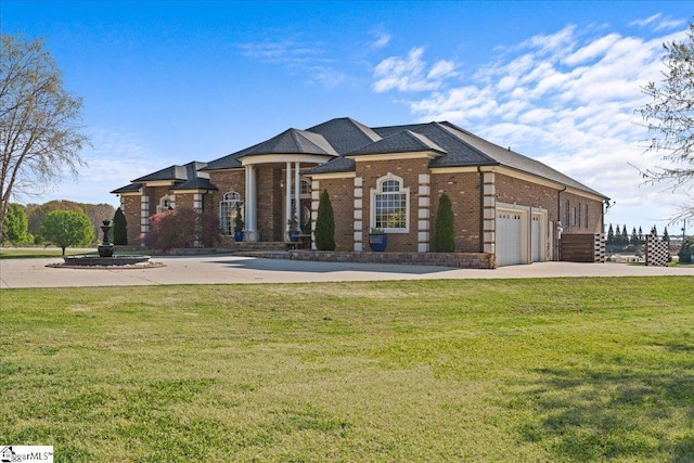view of front of home with brick siding, a front lawn, driveway, and an attached garage