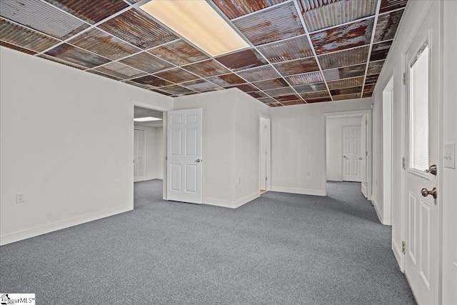 below grade area featuring baseboards and carpet flooring
