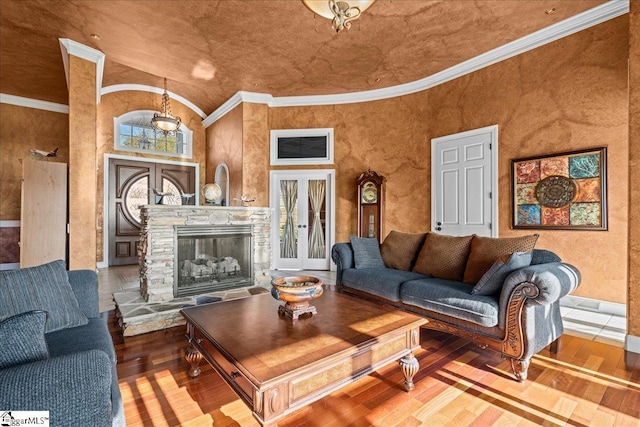 living room featuring french doors, hardwood / wood-style floors, and a stone fireplace