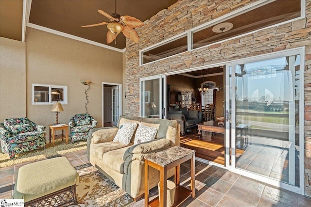 living area with a ceiling fan and crown molding