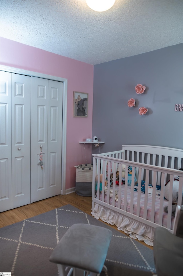 104 Fairview Lake Way, Simpsonville, SC 29680 - bedroom with a crib, a closet, wood finished floors, and a textured ceiling