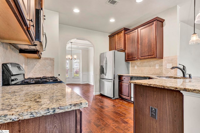 kitchen featuring range, a sink, visible vents, arched walkways, and stainless steel fridge with ice dispenser