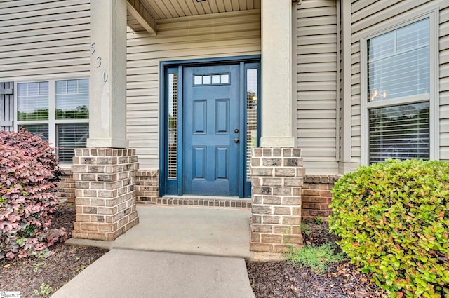 entrance to property with a porch and stone siding