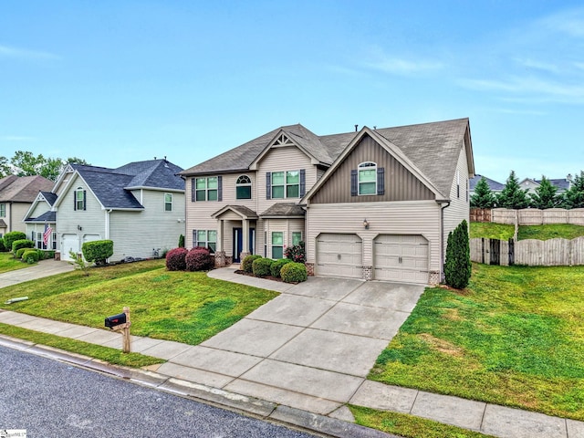 craftsman inspired home featuring a front yard, a garage, driveway, board and batten siding, and fence