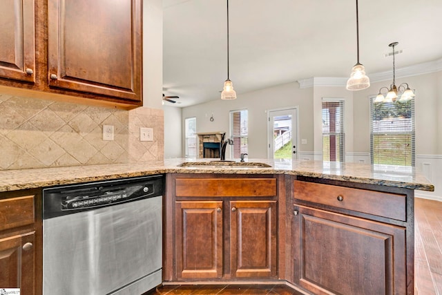 kitchen featuring a healthy amount of sunlight, stainless steel dishwasher, a stone fireplace, and a sink