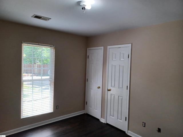 315 Farnsworth Rd, Spartanburg, SC 29301 - unfurnished bedroom with dark wood finished floors, baseboards, and multiple closets