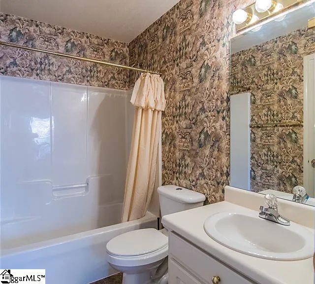 317 Farnsworth Rd, Spartanburg, SC 29301 - bathroom featuring shower / bath combo with shower curtain, vanity, and toilet