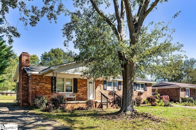411 Granada Dr, Spartanburg, SC 29303 - ranch-style home with fence, a chimney, a porch, and brick siding