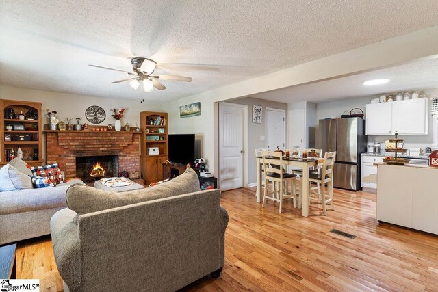 411 Granada Dr, Spartanburg, SC 29303 - living area with a textured ceiling, visible vents, ceiling fan, and light wood-style flooring