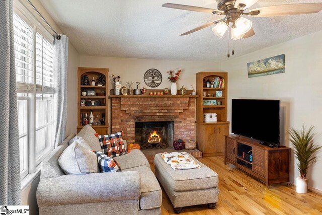 411 Granada Dr, Spartanburg, SC 29303 - living room with a ceiling fan, light wood-style flooring, a textured ceiling, and a fireplace