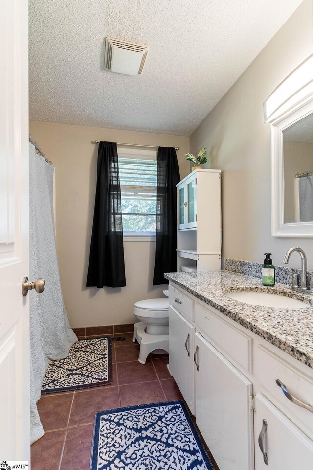 411 Granada Dr, Spartanburg, SC 29303 - bathroom with tile patterned flooring, toilet, vanity, visible vents, and a textured ceiling