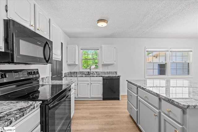 118 Rodney St, Moore, SC 29369 - kitchen with light stone countertops, a sink, black appliances, white cabinetry, and a textured ceiling