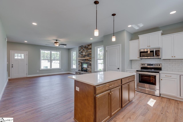 104 Pawleys Ct, Anderson, SC 29625 - kitchen with ceiling fan, light wood-style floors, stainless steel appliances, and a stone fireplace