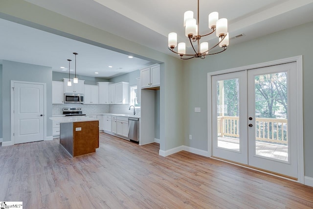 104 Pawleys Ct, Anderson, SC 29625 - kitchen featuring decorative backsplash, stainless steel appliances, light wood-style floors, white cabinets, and french doors
