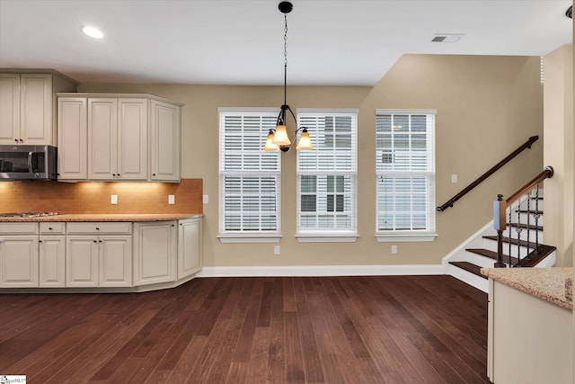 kitchen featuring stainless steel appliances, visible vents, backsplash, baseboards, and dark wood finished floors