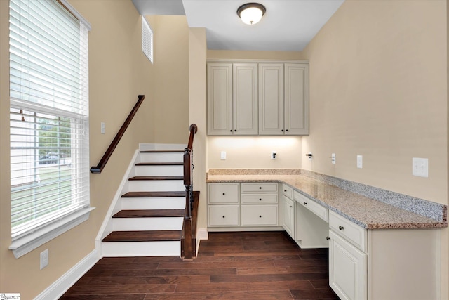 staircase featuring visible vents, built in study area, wood finished floors, and baseboards