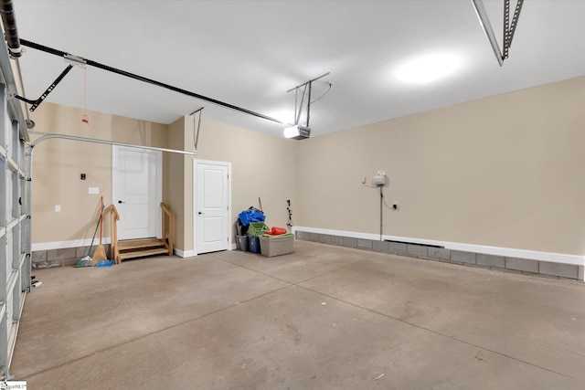 garage featuring a garage door opener and baseboards