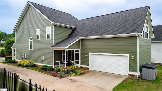 view of front of property featuring a sunroom, driveway, fence, and roof with shingles