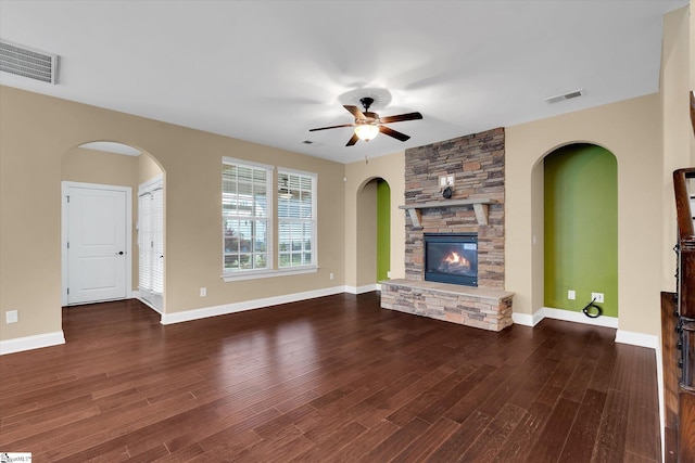 unfurnished living room with a fireplace, ceiling fan, wood finished floors, and visible vents