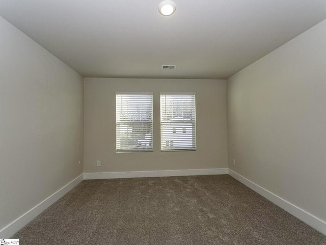 unfurnished room featuring carpet flooring, visible vents, and baseboards
