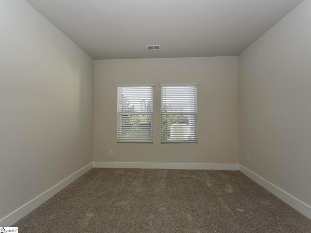 spare room featuring visible vents, baseboards, and carpet floors