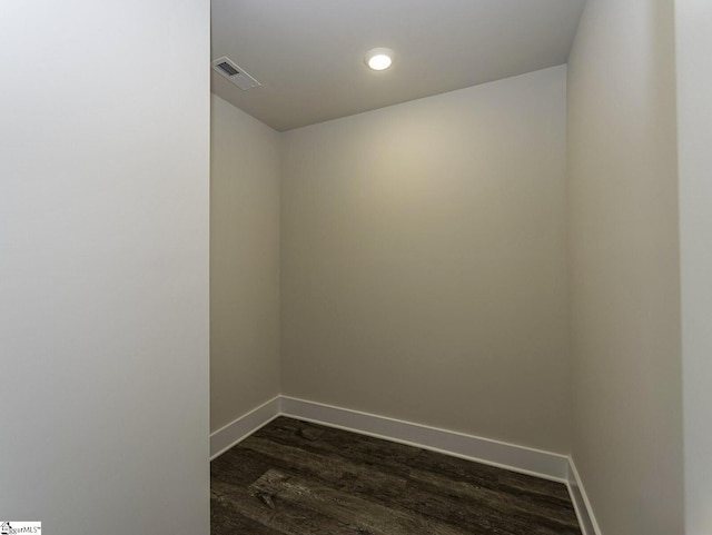 empty room with dark wood-style flooring, visible vents, recessed lighting, and baseboards