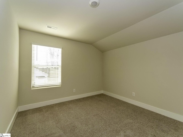 additional living space featuring baseboards, visible vents, carpet, and vaulted ceiling