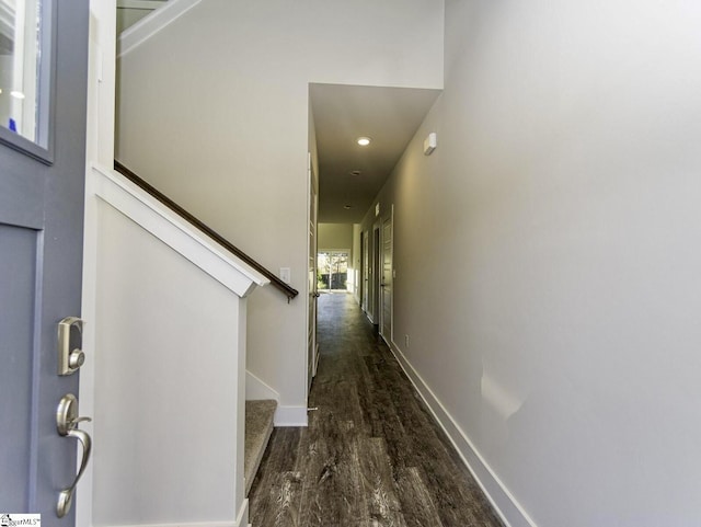 hall featuring dark wood finished floors, baseboards, stairs, and recessed lighting