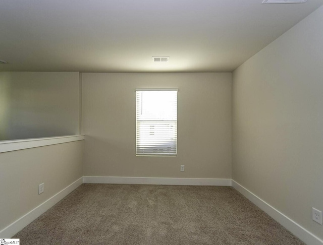 spare room with baseboards, visible vents, and carpet